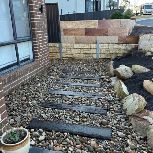 modern landscape design with retaining wall and pebble path