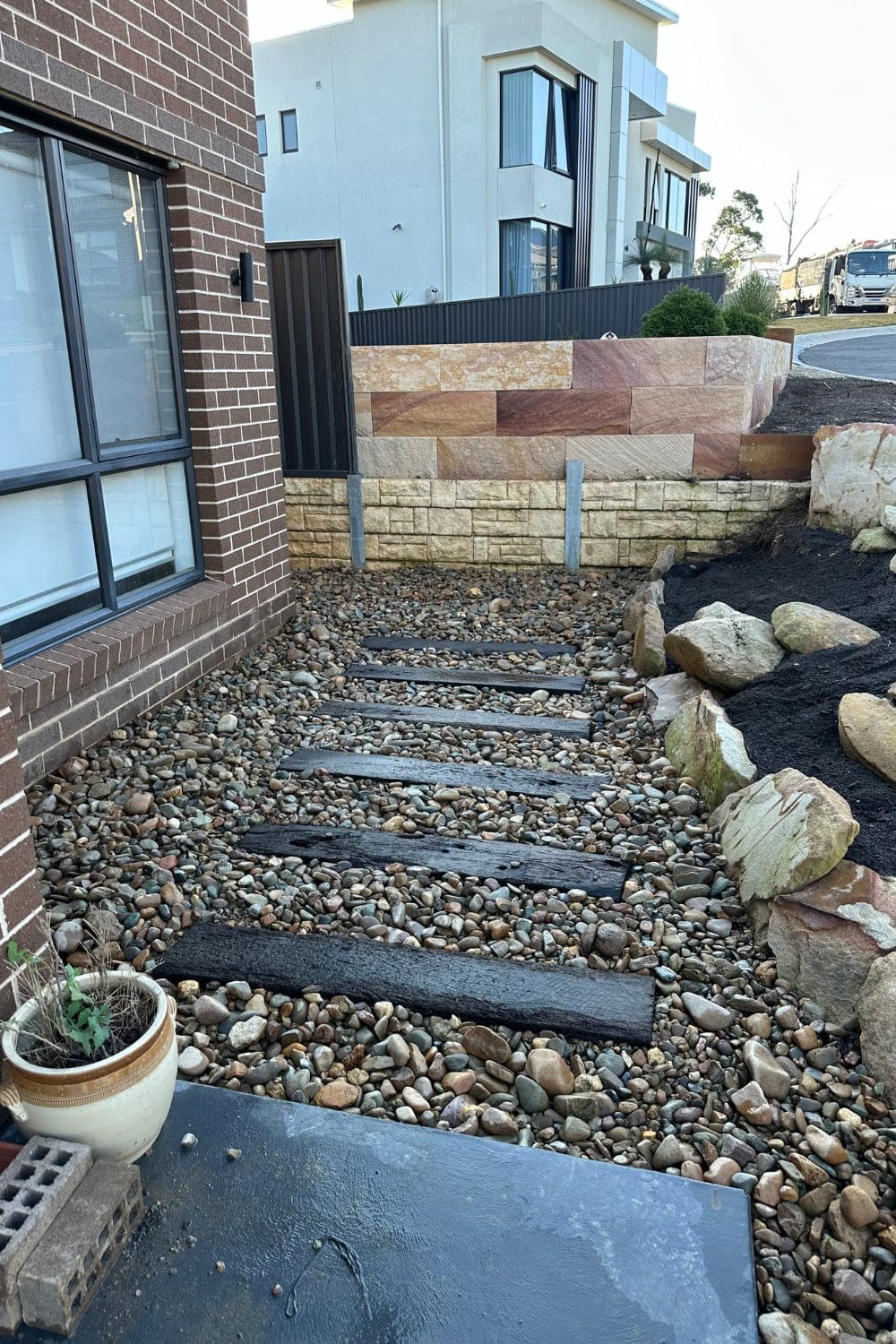 modern landscape design with retaining wall and pebble path