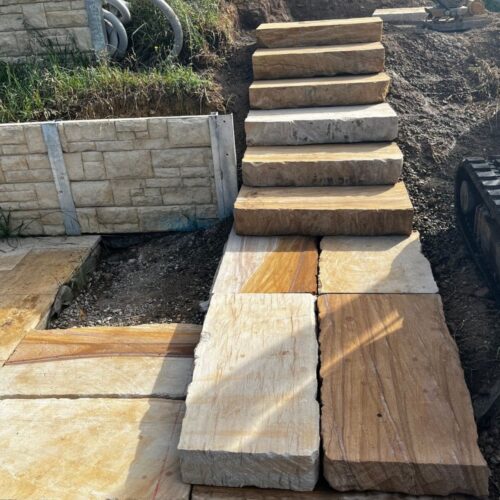 stone step construction in backyard landscape